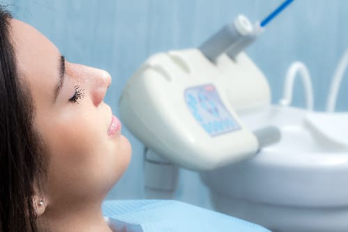 young woman sitting relaxed in a dental chair, routine dental appointment