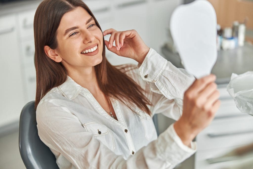 young woman smiling in a dental chair, perfect white smile